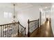 Elegant hallway features a chandelier, dark wood flooring, and detailed trim, highlighting craftsmanship at 2616 Boddie Pl, Duluth, GA 30097