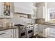 Modern kitchen featuring a large gas range, custom cabinetry, and beautiful granite countertops at 2616 Boddie Pl, Duluth, GA 30097