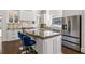 Eat-in kitchen with stainless appliances, custom island with barstool seating, and hardwood floors at 2616 Boddie Pl, Duluth, GA 30097