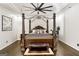 Elegantly designed main bedroom showcasing a four-poster bed, ceiling fan and tray ceiling at 2616 Boddie Pl, Duluth, GA 30097