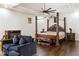 Spacious main bedroom features a four-poster bed, sitting area, tray ceiling and dark hardwood floors at 2616 Boddie Pl, Duluth, GA 30097