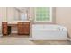 Bright bathroom features a soaking tub and double vanity with wooden cabinets, creating a relaxing retreat at 4616 Town Manor Dr, Douglasville, GA 30135