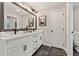 Stylish bathroom featuring a double vanity with sleek fixtures and a modern, geometric tile floor at 4667 Larkfield Way, Powder Springs, GA 30127