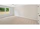 Bright bedroom with light carpet, large window, and neutral paint at 4667 Larkfield Way, Powder Springs, GA 30127