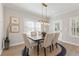 Bright dining room features a modern light fixture and seating for six at 4667 Larkfield Way, Powder Springs, GA 30127