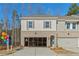 Charming two-story townhome featuring a brick facade, gray siding, and a convenient one-car garage at 4667 Larkfield Way, Powder Springs, GA 30127