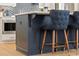 Close-up of a modern kitchen island featuring seating with blue upholstered chairs at 4667 Larkfield Way, Powder Springs, GA 30127