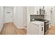 Modern kitchen with stainless steel appliances, white cabinets, and an adjacent entrance hall at 4667 Larkfield Way, Powder Springs, GA 30127