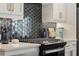 Close-up of a modern kitchen featuring sleek countertops and a stylish tile backsplash at 4667 Larkfield Way, Powder Springs, GA 30127