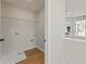 Small laundry room with wood floors and built-in shelf at 4667 Larkfield Way, Powder Springs, GA 30127
