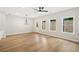 Bright living room with light wood flooring, ceiling fan, and three large windows at 4667 Larkfield Way, Powder Springs, GA 30127