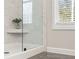 Close up of glass walk-in shower with marble-look tile and a built-in seat at 4667 Larkfield Way, Powder Springs, GA 30127