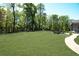Picturesque backyard with a large, well-maintained lawn, mature trees, and a dark wood fence at 5335 Briarstone Ridge Way, Alpharetta, GA 30022