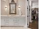 Elegant bathroom with a double vanity, decorative mirror, sconces and easy access to the walk-in closet at 5335 Briarstone Ridge Way, Alpharetta, GA 30022