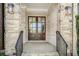 Inviting entryway featuring double doors, stone accents, and decorative lighting fixtures at 5335 Briarstone Ridge Way, Alpharetta, GA 30022