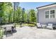 Stone patio with an outdoor dining area and lounge seating, ideal for enjoying the serene backyard at 5335 Briarstone Ridge Way, Alpharetta, GA 30022