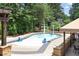 A splash pool with spouts and lounge chairs surrounded by lush greenery with a covered seating area at 5335 Briarstone Ridge Way, Alpharetta, GA 30022