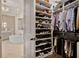 Well-organized closet with custom shelving and a glimpse into the luxurious bathroom with a stand alone tub at 5335 Briarstone Ridge Way, Alpharetta, GA 30022