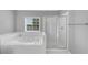 Bright bathroom featuring soaking tub and glass enclosed shower at 566 Vintage Pointe Run, Mableton, GA 30126