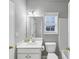 Bright bathroom featuring a single sink vanity, toilet, and a well-lit mirror at 566 Vintage Pointe Run, Mableton, GA 30126