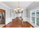 Open dining room with hardwood floors, a chandelier, and a view to the kitchen and entryway at 566 Vintage Pointe Run, Mableton, GA 30126