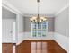 Dining room with hardwood floors, classic chandelier, and views of the front yard at 566 Vintage Pointe Run, Mableton, GA 30126