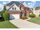Beautiful two-story brick home featuring a two-car garage, manicured lawn, and traditional architectural details at 566 Vintage Pointe Run, Mableton, GA 30126