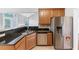 Well-lit kitchen featuring wooden cabinetry, granite countertops, and stainless steel appliances at 566 Vintage Pointe Run, Mableton, GA 30126