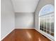 Well-lit living room with hardwood floors, a large arched window, and neutral paint at 566 Vintage Pointe Run, Mableton, GA 30126