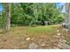 Large backyard with grass, mature trees and a storage tank at 1520 Oxford St, Douglasville, GA 30134