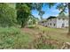 Expansive backyard featuring a white brick home, partially fenced yard, and mature trees at 1520 Oxford St, Douglasville, GA 30134
