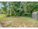 Large, grass backyard partially enclosed with fencing and mature trees at 1520 Oxford St, Douglasville, GA 30134