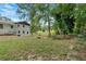 Grassy backyard, partially fenced in, featuring a fire pit, and mature trees at 1520 Oxford St, Douglasville, GA 30134