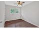 This bedroom features hardwood floors, a ceiling fan, and a window with natural light at 1520 Oxford St, Douglasville, GA 30134