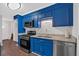 Stylish kitchen with bright blue cabinets, stainless steel appliances, and modern granite countertops at 1520 Oxford St, Douglasville, GA 30134