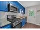 Updated kitchen boasts stainless appliances, granite countertops, and bright painted cabinetry at 1520 Oxford St, Douglasville, GA 30134