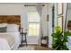 Bedroom featuring a wooden headboard, bright window, and stylish side table decor at 780 Old Magnolia Trl, Canton, GA 30115