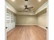 Bonus room featuring built-in shelving, wooden floors, and a tray ceiling at 1632 Brookhaven Close Ne, Atlanta, GA 30319