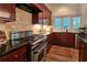Kitchen featuring stainless steel appliances, dark wood cabinets, and granite countertops at 1632 Brookhaven Close Ne, Atlanta, GA 30319