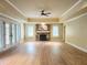 Bright living room featuring a stone fireplace, crown molding, ceiling fan, and wooden floors at 1632 Brookhaven Close Ne, Atlanta, GA 30319