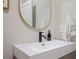 Modern bathroom sink with matte black faucet, round mirror, and neutral tones, providing a sleek design at 354 Hayden Cir, Woodstock, GA 30189
