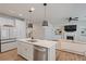 Open-concept kitchen with stainless appliances, island, and seamless flow into the living room with a fireplace at 354 Hayden Cir, Woodstock, GA 30189
