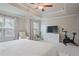 Spacious main bedroom featuring a tray ceiling, ceiling fan, seating area, and large windows providing natural light at 354 Hayden Cir, Woodstock, GA 30189