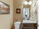 Cozy half bathroom has framed artwork, granite countertop, and unique decor at 55 Sudderth St, Buford, GA 30518