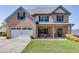 Charming two-story brick home featuring a well-maintained front yard and attached two-car garage at 55 Sudderth St, Buford, GA 30518