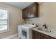 Laundry room featuring a granite countertop sink, modern washer and dryer, and cabinets at 55 Sudderth St, Buford, GA 30518