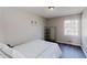This bedroom features wood-look flooring, a bright window, and a modern metal shelving unit at 8451 Magnolia Dr, Jonesboro, GA 30238