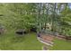 A view of the backyard with a fence, a grassy area, a trampoline, raised garden beds, and mature trees at 10090 Feather Sound Ct, Alpharetta, GA 30022
