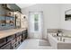 Bright bathroom featuring a soaking tub, double vanity, and modern finishes at 10090 Feather Sound Ct, Alpharetta, GA 30022