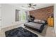 Bedroom featuring a brick accent wall, ceiling fan, and great natural light at 10090 Feather Sound Ct, Alpharetta, GA 30022